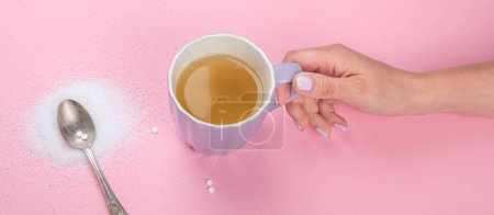 Foto de Cup of tea with sugar substitute on pink background. Healthy hot beverage. Top view, flat lay, copy space - Imagen libre de derechos