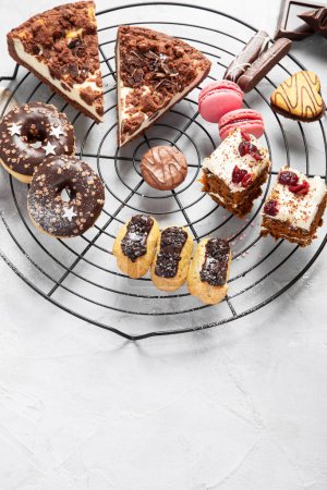 Photo for Table with various cookies, donuts, cakes and coffe cups on light backround. Top view. - Royalty Free Image