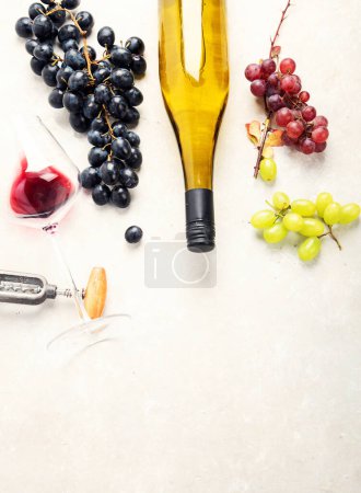 Foto de Degustación de vinos. Una foto aérea de copas de vino tinto y blanco con una botella, uvas y un corcho vintage y corchos, disparados desde arriba sobre un fondo claro. - Imagen libre de derechos