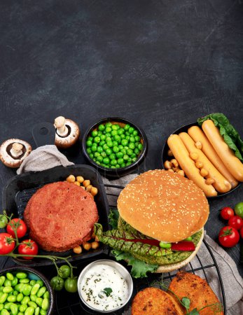 Foto de Hamburguesas vegetarianas, salchichas, nuggets vegetarianos, verduras frescas y salsas en un fondo oscuro. vista superior. - Imagen libre de derechos