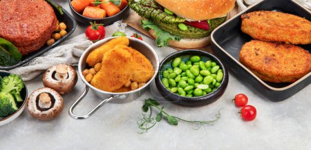 Photo for Plant-based food concept-vegan burgers, sausages, vegetarian nuggets, fresh vegetables and sauces on a white background. Top view. Panorama with copy space. - Royalty Free Image