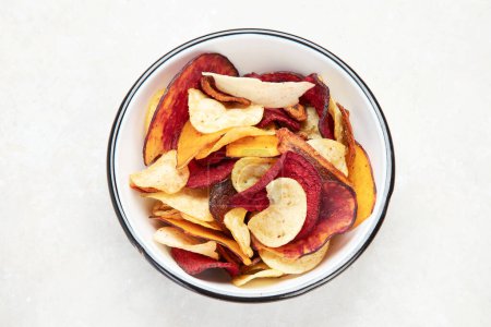 Photo for Bowl of mixed healthy vegetable chips isolated on a white background. Top view. - Royalty Free Image