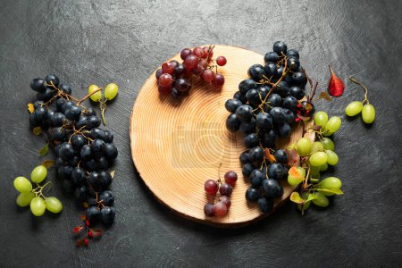 Photo for Green and black grapes on a wooden plate. Top view. - Royalty Free Image