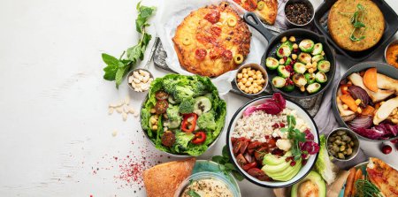 Foto de Vegetarian and various vegan dishes on grey  table. Healthy food concept with vitamins, fiber and antioxidants. Top view. Panorama with copy space. - Imagen libre de derechos