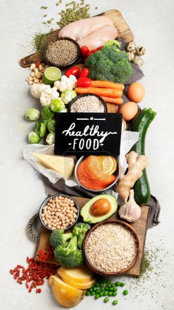 Foto de Healthy food selection on white background. Detox and clean diet concept. Foods high in vitamins, minerals and antioxidants. Anti age foods. Top view. - Imagen libre de derechos