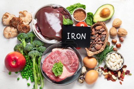Foto de Food containing natural iron. Fe: Liver, avocado, broccoli, spinach, parsley, beans, nuts, on a white background. Top view. - Imagen libre de derechos