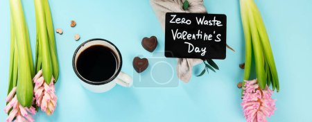 Foto de Morning cup of coffee, candy, gift or present box and pink spring flowers on blue background. Breakfast for Birthday, Holiday, Women day, Mother day,. Zero waste Valentine's Day concept, panorama, banner - Imagen libre de derechos