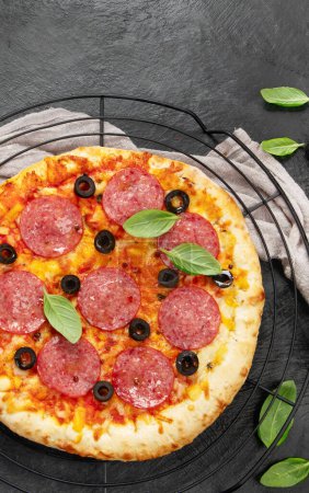 Téléchargez les photos : Freshly baked pepperoni pizza on dark background. Tasty homemade food concept. Top view, copy space - en image libre de droit