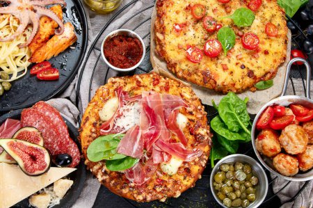 Photo for Dinner table of italian meals dishes.  Pizza, pasta, antipasto  on black background. Healthy eating concept. Top view - Royalty Free Image