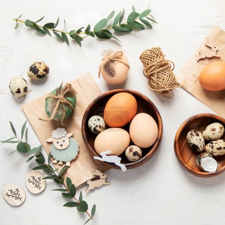 Téléchargez les photos : Easter eggs decorated with natural materials on a white background. Top view. Minimalistic decor for Easter. - en image libre de droit