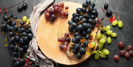 Photo for Green and black grapes on a wooden plate. Top view. Panorama. - Royalty Free Image