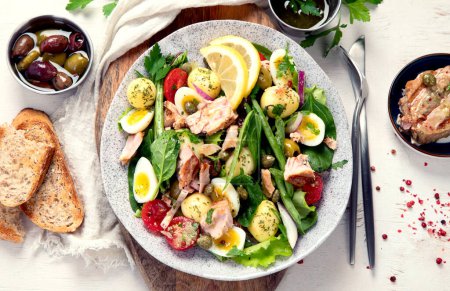Photo for Nicoise salad,  traditional French dish with canned tuna. Tuna salad, healthy mediterranen diet. Top view, flat lay - Royalty Free Image