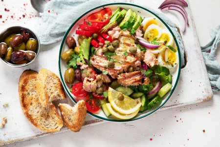 Photo for Tuna salad with boiled egg, tomato, lettuce, cucumber and red onion. Healthy and detox food concept. Ketogenic diet. Fresh vegetable salad bowl on white background. Top view. - Royalty Free Image
