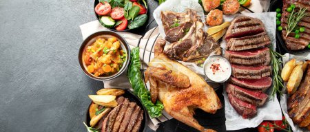 Photo for Various types of healthy cooked meat - beef, pork, chicken on a dark background with vegetables and salad. Top view. Panorama with copy space. - Royalty Free Image