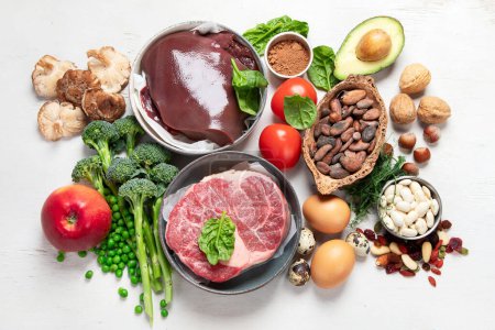Téléchargez les photos : Food containing natural iron. Fe: Liver, avocado, broccoli, spinach, parsley, beans, nuts, on a white background. Top view. - en image libre de droit