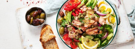 Foto de Tuna salad with boiled egg, tomato, lettuce, cucumber and red onion. Healthy and detox food concept. Ketogenic diet. Fresh vegetable salad bowl on white background. Top view. Panorama, banner. - Imagen libre de derechos