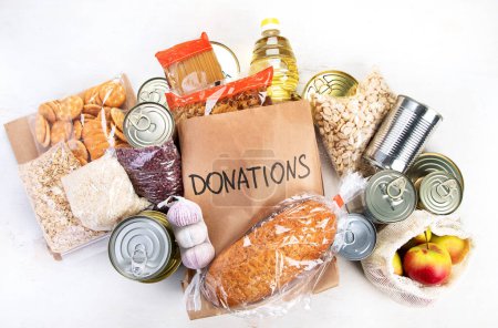 Photo for Food donations with pasta, rice, oil, peanut butter, canned food, jam and other  on light background, top view. Food donations or delivery concept. - Royalty Free Image