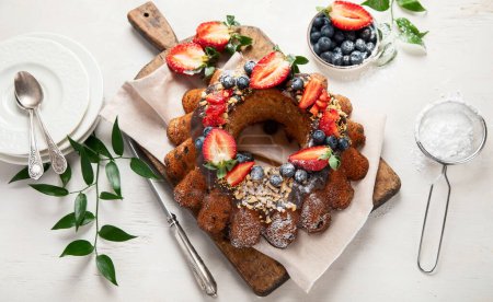 Téléchargez les photos : Gâteau Bundt avec fraise et baies sur un fond clair. Gâteau festif. Vue du dessus. - en image libre de droit