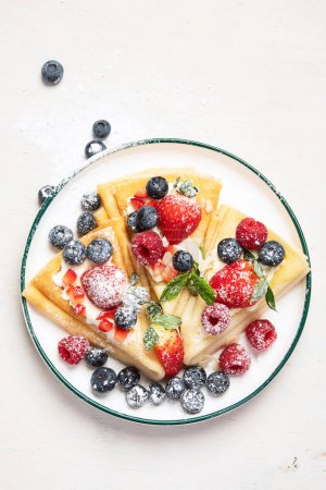 Photo for Healthy breakfast, homemade traditional crepes or pancakes with fresh berries, morning light background. Copy space top view - Royalty Free Image