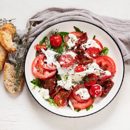 Téléchargez les photos : Tomato, basil, mozzarella. Caprese salad with olive oil. Top view, white background. - en image libre de droit