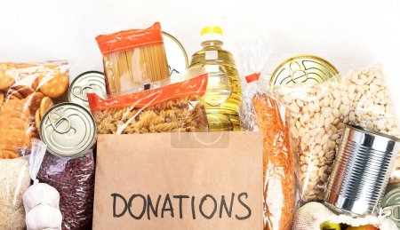 Photo for Food donations with pasta, rice, oil, peanut butter, canned food, jam and other  on light background, top view with copy space. Food donations or delivery concept. - Royalty Free Image