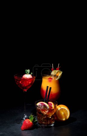 Foto de Conjunto de varios cócteles de colores sobre fondo negro. Concepto clásico de menú de cócteles de bebida larga. Copiar, espacio - Imagen libre de derechos