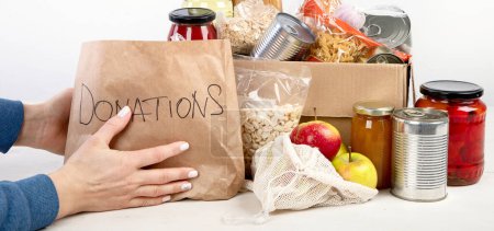 Foto de Caja de donación de alimentos de diferentes productos sobre fondo claro, vista superior. Donaciones de alimentos o concepto de entrega. - Imagen libre de derechos