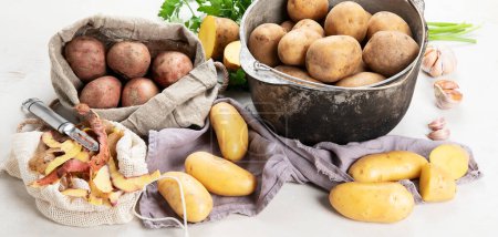 Raw potato food. Fresh potatoes in an old cooking pot on a white background. Top view