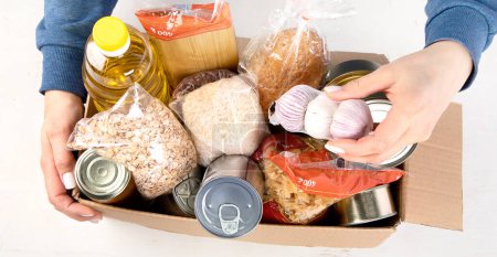 Photo for Food donation box of different products  on light background, top view. Food donations or delivery concept. - Royalty Free Image
