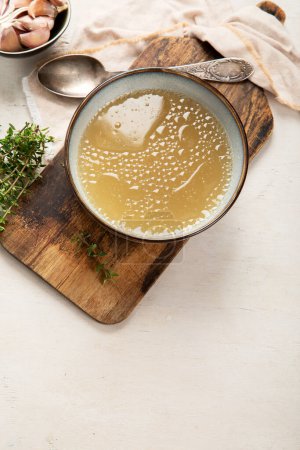 Broth in Bowl on gray background, healthy food, top view, copy space