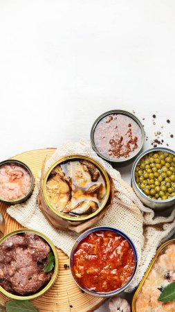 Foto de Varias verduras enlatadas, carne, pescado y frutas en latas. Sobre un fondo blanco. Vista superior. - Imagen libre de derechos