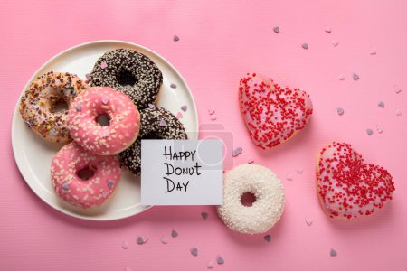 Téléchargez les photos : Donuts beignets au chocolat, guimauve et sucre saupoudrés sur fond rose, vue de dessus. Carnaval coloré ou carte de fête d'anniversaire. Bonne Journée nationale des beignets Concept. - en image libre de droit