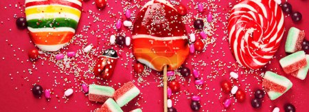 Téléchargez les photos : Collection mixte de bonbons colorés, sur fond rose. Vue de dessus. Panorama, bannière. - en image libre de droit