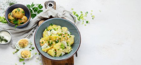 Téléchargez les photos : Salade de pommes de terre, œufs, oignons verts et mayonnaise sur fond blanc, vue sur le dessus. Panorama avec espace de copie - en image libre de droit
