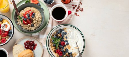 Photo for Breakfast food table. Healthy breakfast or brunch set, meal variety with granola, porridge, cornflakes, fresh berries, fruits and various of topping on a white background. Top view. Panorama with copy space. - Royalty Free Image