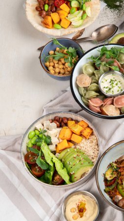 Photo for Fresh and healthy vegan table with chickpea, buddha bowl, pumpkins, broccoli, quinoa, sprout and other. Light background. Top view. Copy space. - Royalty Free Image