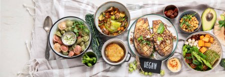Photo for Fresh and healthy vegan table with chickpea, buddha bowl, pumpkins, broccoli, quinoa, sprout and other. Light background. Top view. Panorama. - Royalty Free Image