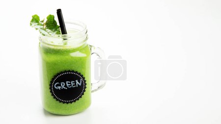 Foto de Smoothie verde sano en una taza del frasco sobre fondo blanco. - Imagen libre de derechos