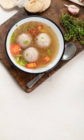 Photo for Knodel soup bowl and bread on light backround - Royalty Free Image