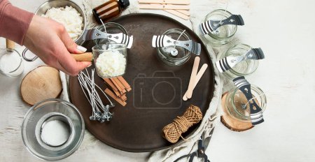 Téléchargez les photos : Set pour bougies de cire de soja écologique naturel fait maison, femme faisant bougie d'arôme décoratif à la table - en image libre de droit