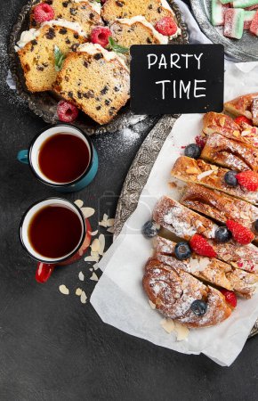 Foto de Tiempo de fiesta, vista superior de la mesa con pasteles de galletas dulces, comida de panadería, frutas y té - Imagen libre de derechos