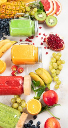 Foto de Batidos de frutas y verduras frescas o zumos con varios ingredientes sobre fondo claro. Vista superior - Imagen libre de derechos