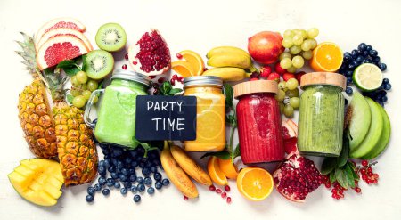 Foto de Batidos de frutas y verduras frescas o zumos con varios ingredientes sobre fondo claro. Vista superior, espacio de copia - Imagen libre de derechos