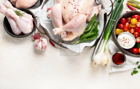 Photo for Poultry. Carcass and meat in pieces with vegetables. Meat composition on a white background. Top view - Royalty Free Image