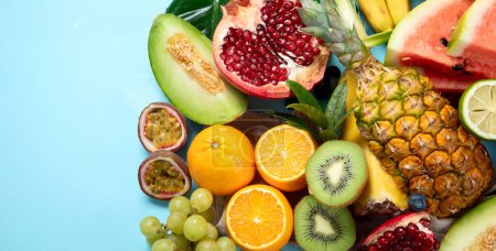 Photo for Fresh fruits assorted on a blue background. Vitamins natural nutrition concept. Top view. Panorama with copy space. - Royalty Free Image