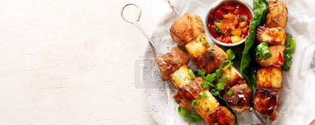 Photo for Kebabs - grilled meat skewers, shish kebab with sauce on a white background. top view. Panorama with copy space. - Royalty Free Image