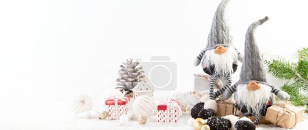 Téléchargez les photos : Composition de Noël avec gnomes et décorations festives sur fond blanc. Carte de voeux de Noël ou Nouvel An. Panorama avec espace de copie. - en image libre de droit