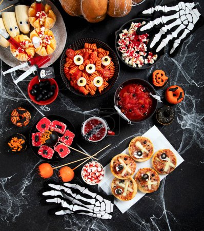 Téléchargez les photos : Bonbons d'Halloween pour fête d'Halloween sur fond noir. vue du dessus, espace de copie - en image libre de droit
