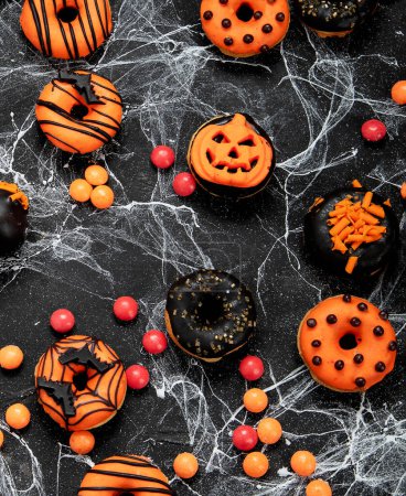 Téléchargez les photos : Bonbons d'Halloween pour fête d'Halloween sur fond noir. vue de dessus. - en image libre de droit