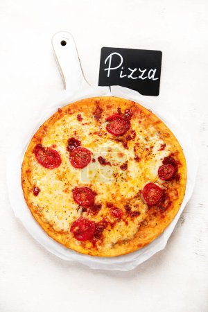 Téléchargez les photos : Pizza Margherita sur fond blanc, vue de dessus. Pizza Margarita aux tomates et fromage Mozzarella. Vue du dessus. - en image libre de droit